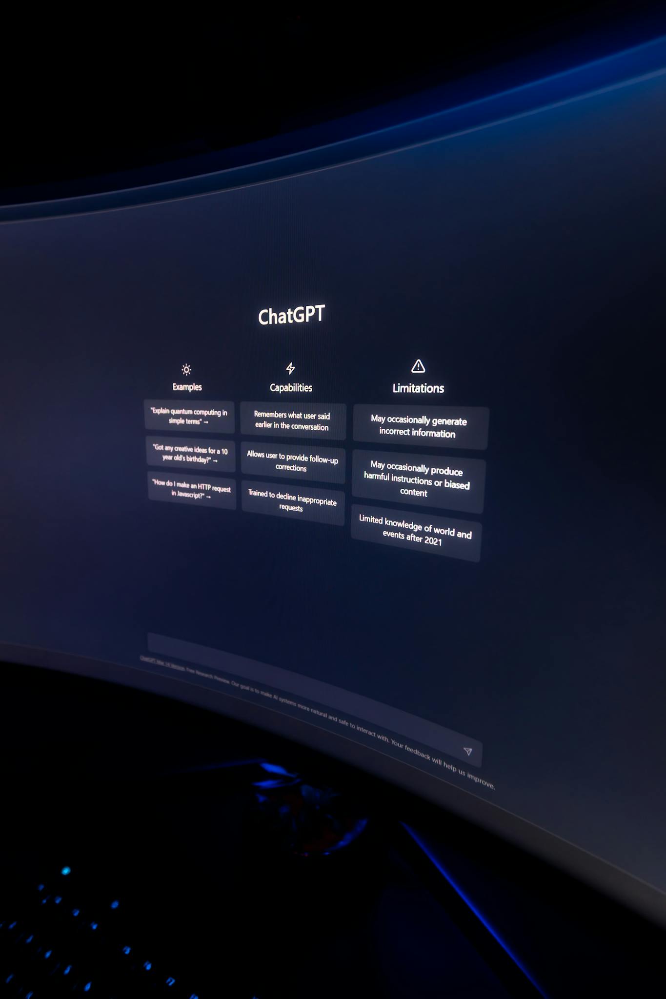 Close-up of ChatGPT's interface displayed on a curved monitor in a dimly lit environment.